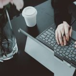 A woman typing on a computer, signifying tax technology in compliance.