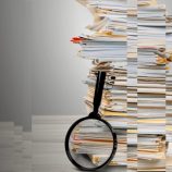 A picture of a stack of files and a magnifying glass, representing the need for good digital record-keeping practices to simplify records.