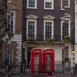 A picture of a London street with two red phone boxes.
